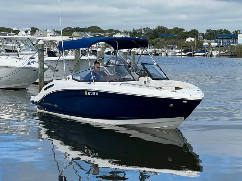 Slide: The Image of 2016 Chaparral 257 SSX on calm water, featuring a blue canopy and white details. - 11
