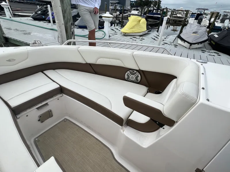Slide: The Image of Interior view of a 2016 Chaparral 257 SSX with white and brown seating at the dock. - 15