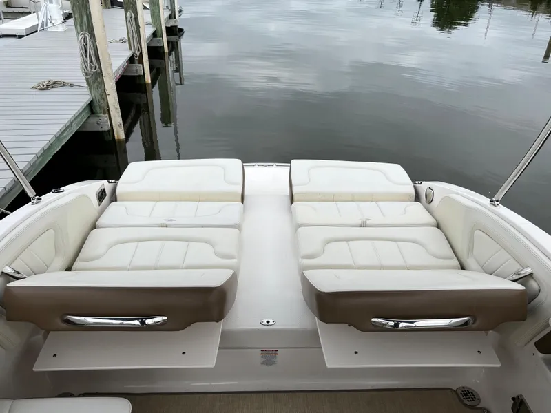 Slide: The Image of The image shows the stern of a 2016 Chaparral 257 SSX boat with lounge seating by the water. - 21