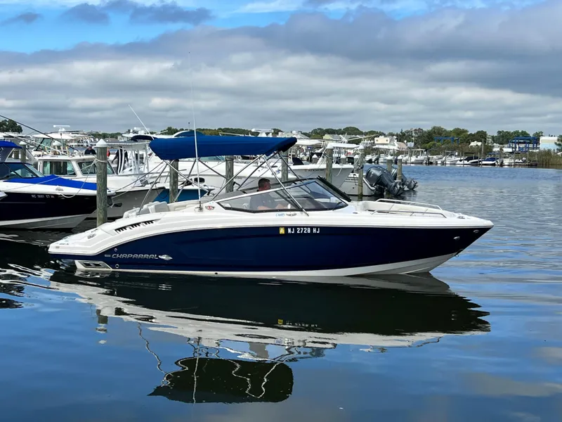 Slide: The Image of A 2016 Chaparral 257 SSX boat is on the water, surrounded by other boats in the harbor. - 4