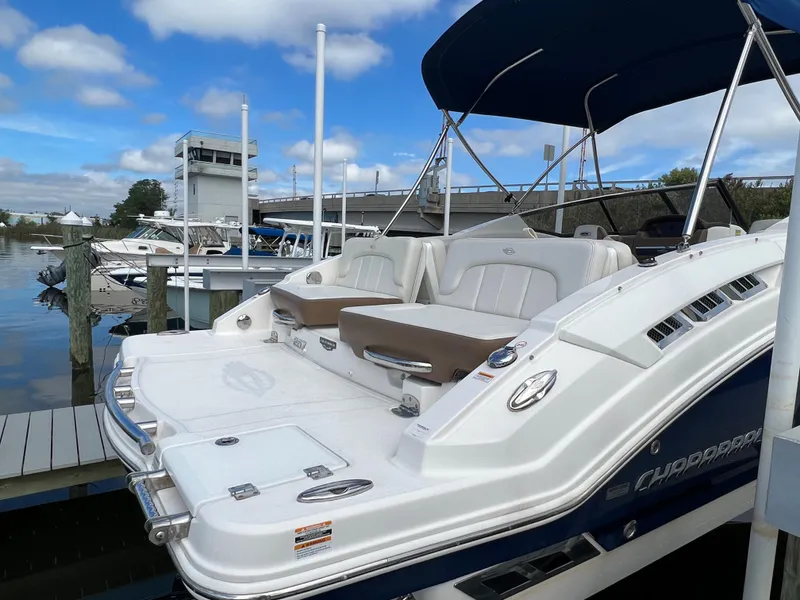 Slide: The Image of A 2016 Chaparral 257 SSX boat docked. It features a blue and white design. - 7