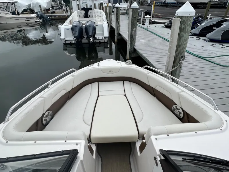 Slide: The Image of The image shows the bow seating area of a 2016 Chaparral 257 SSX boat docked. - 47