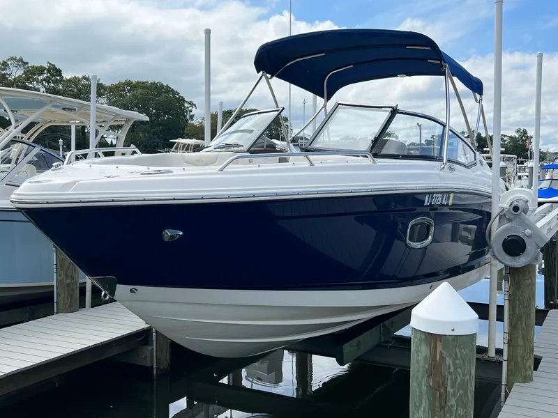 Slide: The Image of A 2016 Chaparral 257 SSX boat docked. It features a blue and white design. - 5