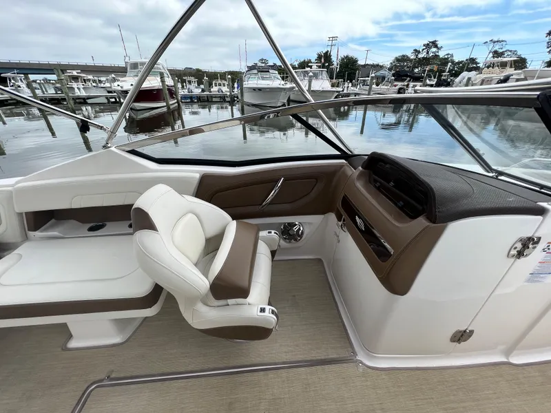 Slide: The Image of The image shows the cockpit of a 2016 Chaparral 257 SSX boat at a marina. - 13
