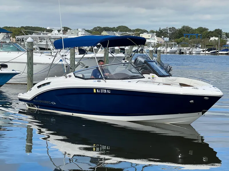 Slide: The Image of A 2016 Chaparral 257 SSX boat is docked on the water, surrounded by other boats. - 10