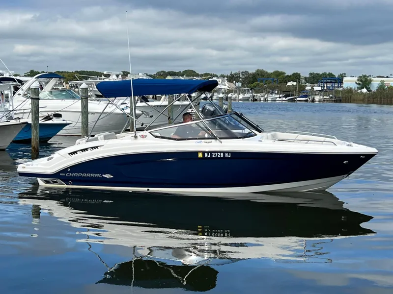 The Image of A 2016 Chaparral 257 SSX boat on the water, surrounded by other boats and a cloudy sky. - 1