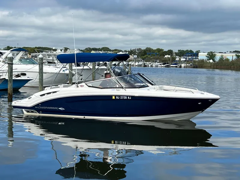 Slide: The Image of A 2016 Chaparral 257 SSX is on the water, surrounded by other boats and a cloudy sky. - 9
