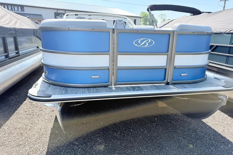 Slide: The Image of 2027 Bentley Pontoons Legacy 240 Navigator, blue and white pontoon boat, parked outdoors. - 2