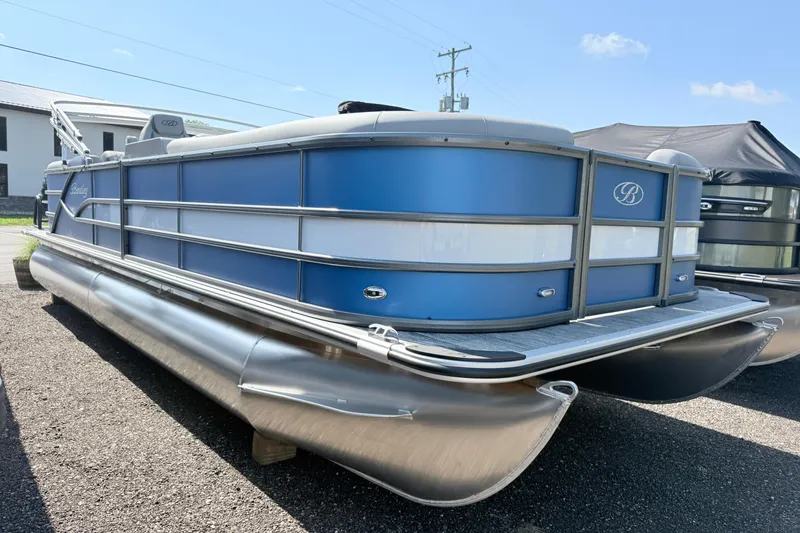 The Image of 2027 Bentley Pontoons Legacy 240 Navigator, blue and silver pontoon boat, parked outdoors. - 1