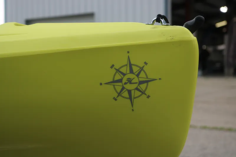 Slide: The Image of Yellow 2025 Hobie Mirage Compass kayak with compass design on the side. - 5