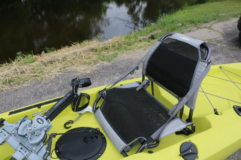 Slide: The Image of 2025 Hobie Mirage Compass kayak with adjustable seat by a riverside. - 1