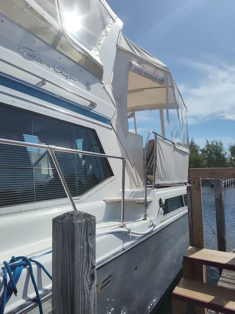 Slide: The Image of The 1989 Chris-Craft 372 Catalina is docked at a wooden pier, featuring a white canopy. - 34