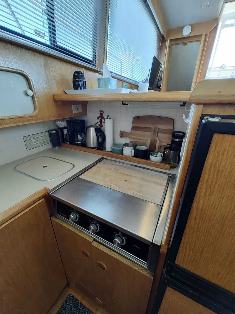 Slide: The Image of 1989 Chris-Craft 372 Catalina kitchen with stove, coffee maker, and wooden cabinets. - 48