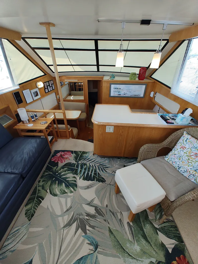 Slide: The Image of Interior of a 1989 Chris-Craft Catalina with cozy seating and a decorative rug. - 10