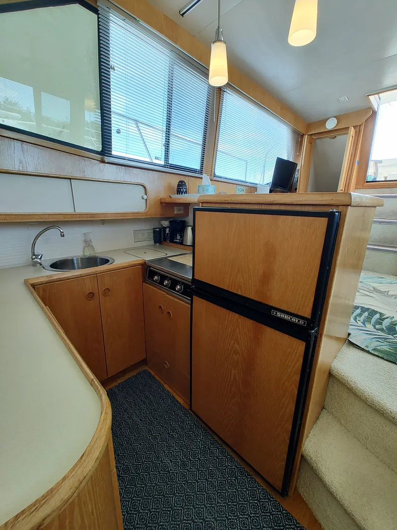 Slide: The Image of Interior of a 1989 Chris-Craft Catalina with kitchen, fridge, and sink. - 17