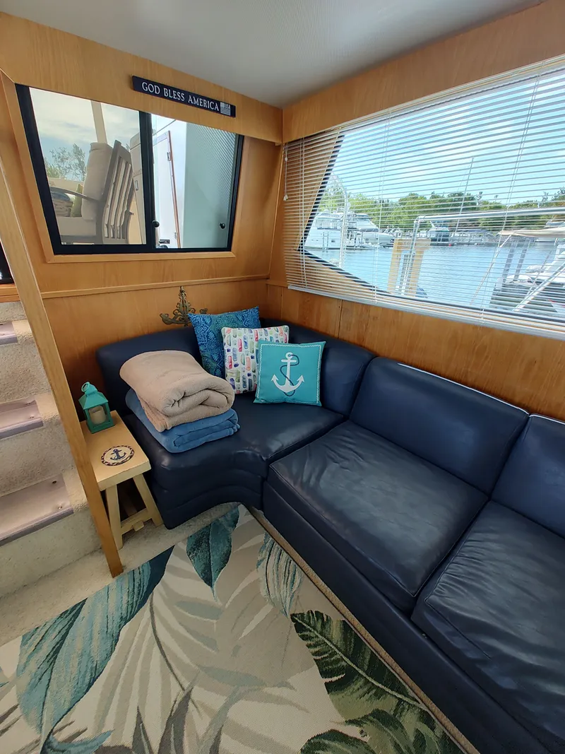 Slide: The Image of Interior of a 1989 Chris-Craft Catalina with blue leather couch and nautical decor. - 11