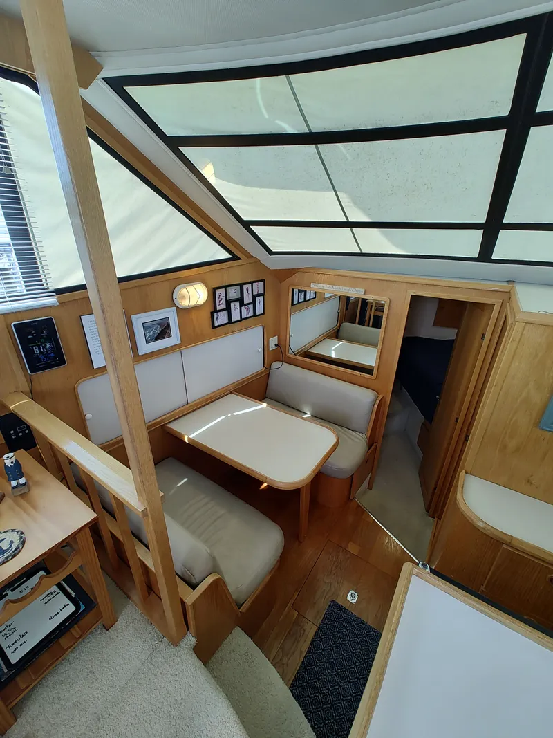 Slide: The Image of Interior of a 1989 Chris-Craft Catalina with cozy seating area and wood finish. - 15