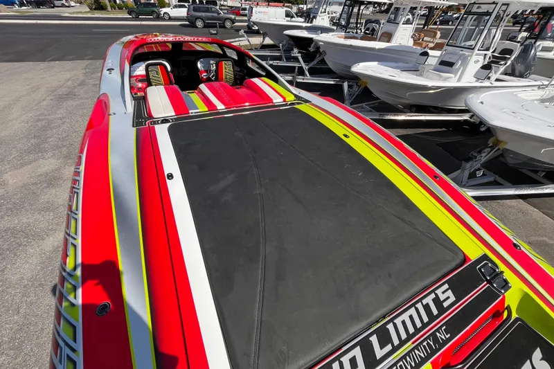 Slide: The Image of 2007 Outerlimits 39 GTX speedboat with vibrant red, yellow, and silver design, docked among other boats. - 9