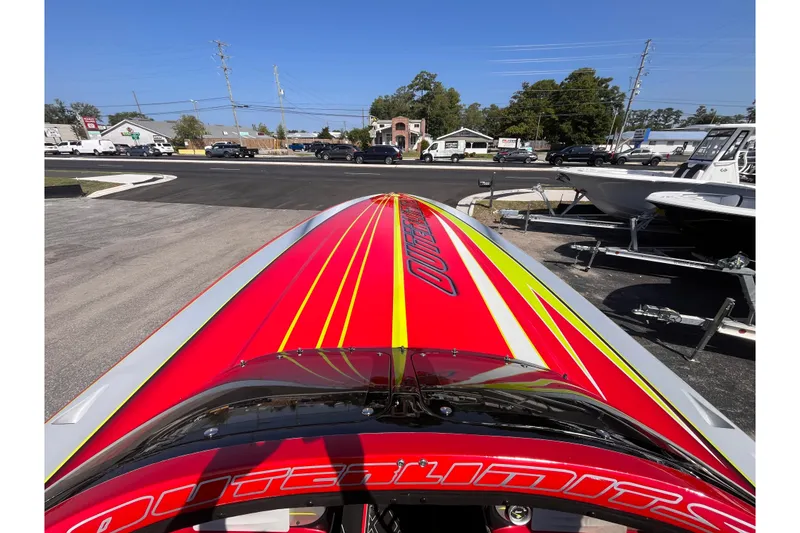 Slide: The Image of 2007 Outerlimits 39 GTX boat with vibrant red and yellow design, parked outdoors. - 20