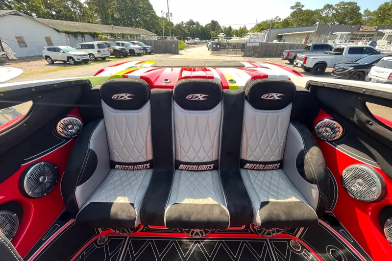 Slide: The Image of Interior of a 2007 Outerlimits 39 GTX boat with four stylish seats and vibrant red accents. - 11