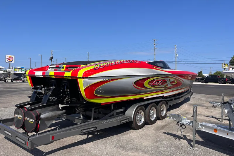 Slide: The Image of 2007 Outerlimits 39 GTX powerboat on trailer, vibrant red and yellow design. - 5