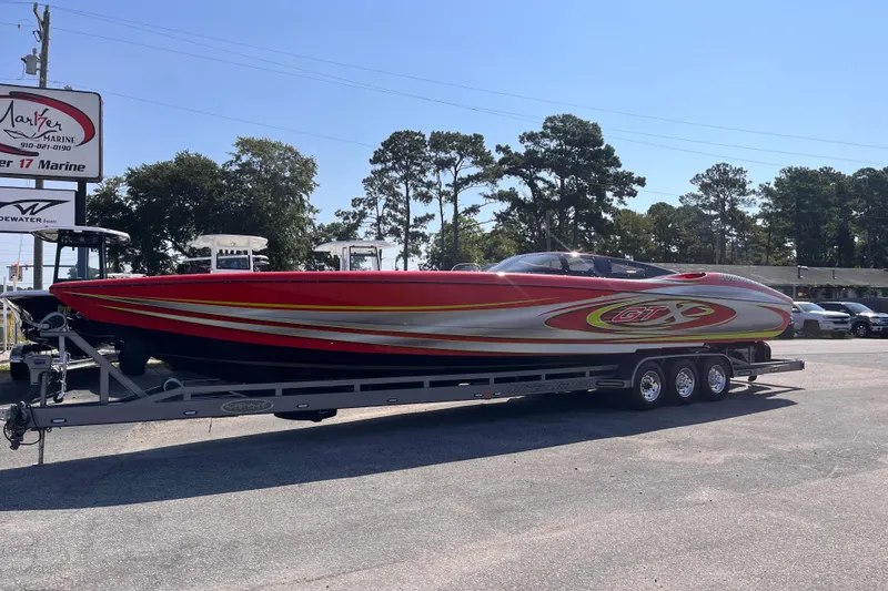 Slide: The Image of 2007 Outerlimits 39 GTX powerboat on trailer, vibrant red and silver design, parked outdoors. - 2