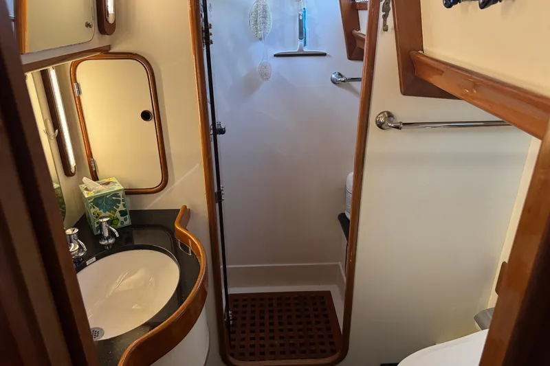 Slide: The Image of 1989 Mason 54 yacht bathroom with wooden accents, sink, and shower area. - 33