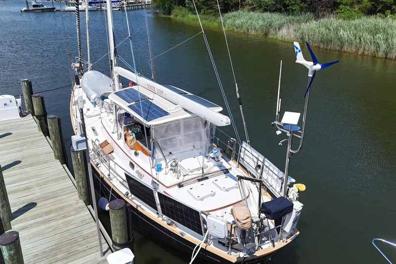 Slide: The Image of Sailboat docked in a marina, Mason 54 model, 1989, with solar panels and wind turbine. - 61