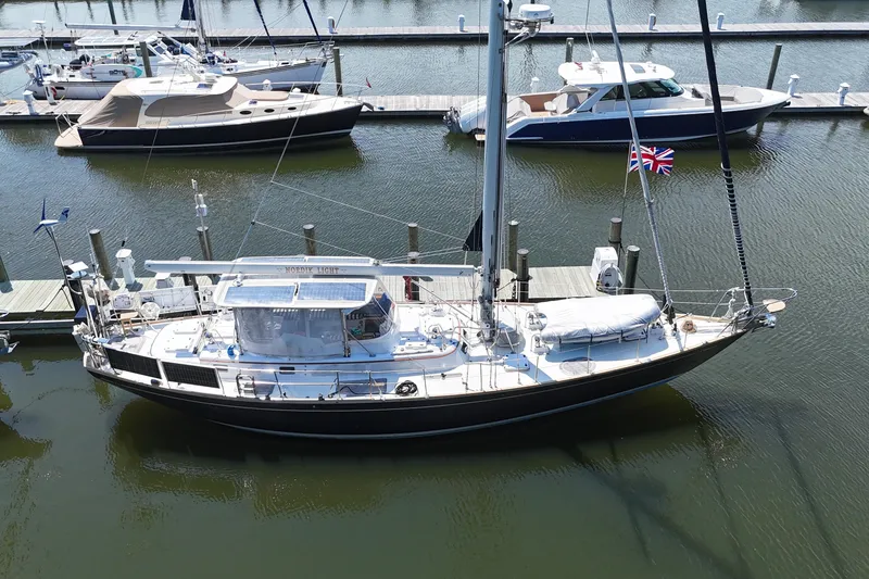The Image of Sailboat docked in marina, Mason 54 model, 1989, with British flag. - 0
