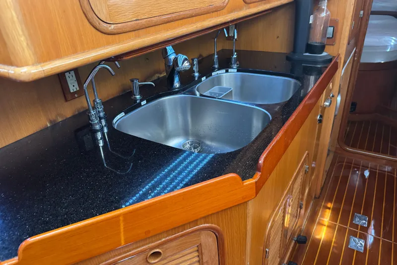 Slide: The Image of Luxury yacht kitchen with dual sinks, granite countertop, and wooden cabinetry, Mason 54, 1989 model. - 18