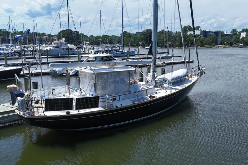 Slide: The Image of Sailboat docked at marina, Mason 54 model, 1989, with solar panels and clear skies. - 63