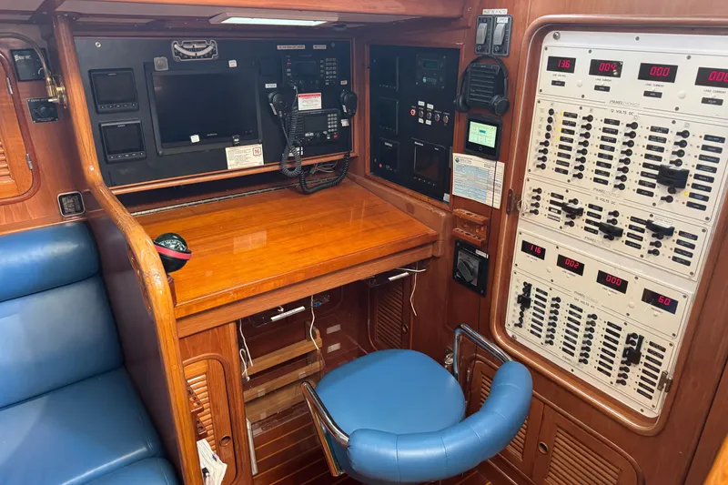 Slide: The Image of Navigation station in a 1989 Mason 54 yacht with control panels and seating. - 24