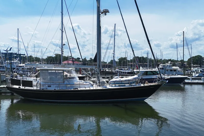 Slide: The Image of Sailboat Mason 54, 1989 model, docked in a marina under a clear sky. - 65