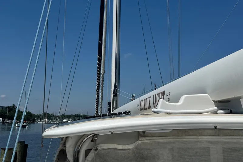 Slide: The Image of Sailboat docked at marina, featuring Mason 54 model from 1989 under clear blue sky. - 53
