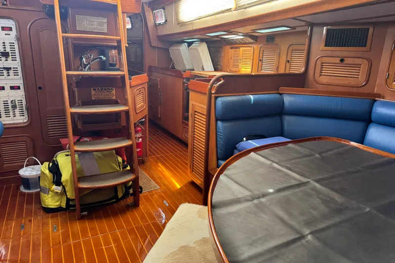 Slide: The Image of Interior of a 1989 Mason 54 yacht with wooden finishes and blue seating. - 12