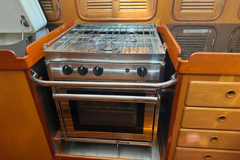 Slide: The Image of 1989 Mason 54 yacht kitchen with stainless steel stove and wooden cabinetry. - 21