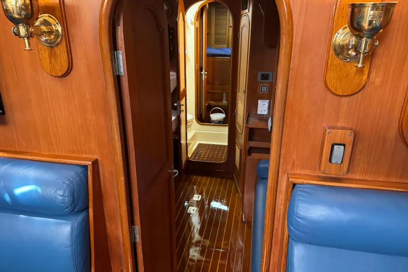 Slide: The Image of Interior of a 1989 Mason 54 yacht, featuring polished wood and blue leather seating. - 10
