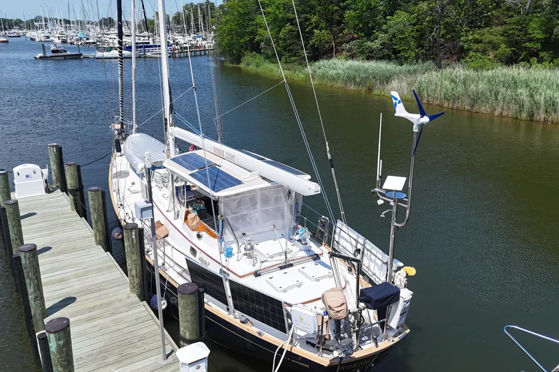 Slide: The Image of Sailboat docked at marina, Mason 54 model, 1989, with solar panels and wind turbine. - 59