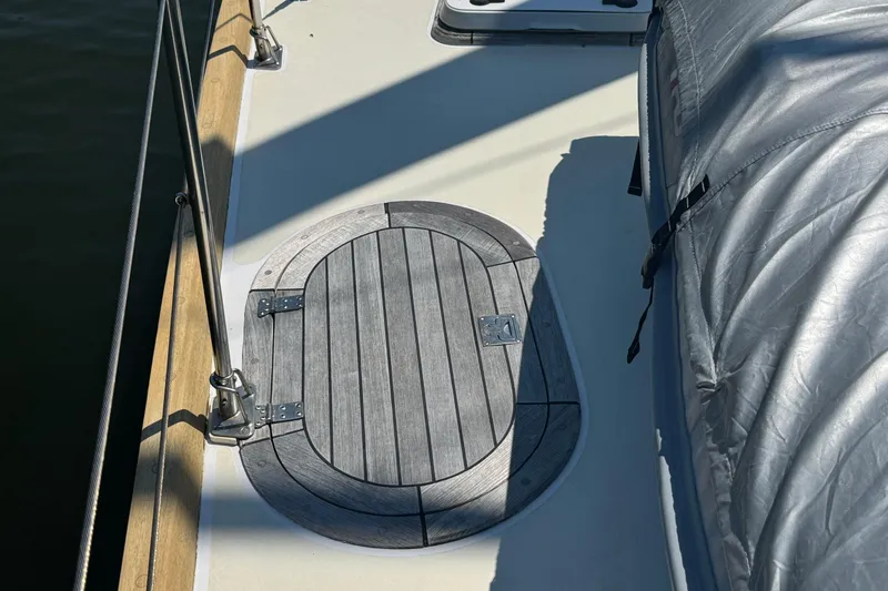 Slide: The Image of Deck of 1989 Mason 54 sailboat with wooden hatch and covered equipment. - 49