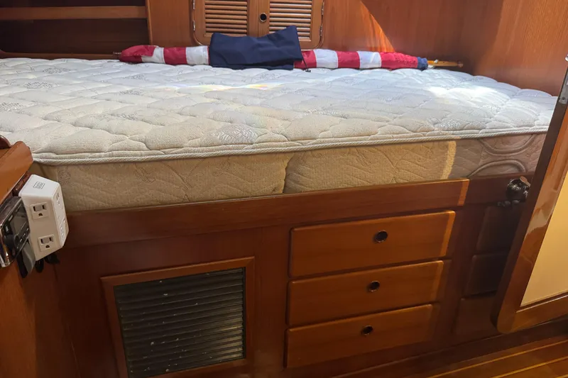 Slide: The Image of Wooden cabin interior with mattress, drawers, and power outlets on a 1989 Mason 54 yacht. - 5