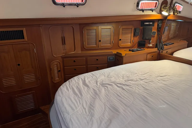 Slide: The Image of Cozy cabin interior of 1989 Mason 54 yacht with wooden cabinetry and bed. - 32