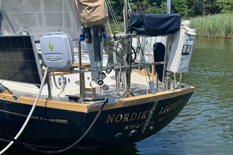 Slide: The Image of Sailboat "Nordik Light" docked, featuring solar panel and safety equipment, Mason 54 model, 1989. - 58