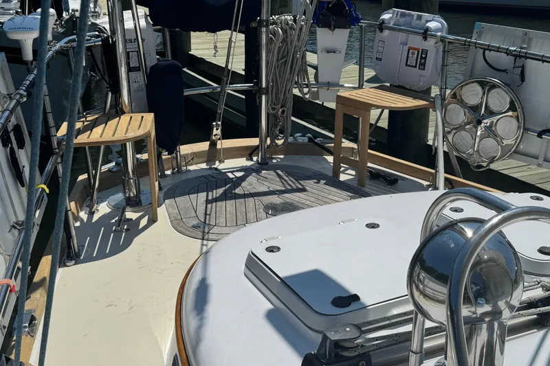 Slide: The Image of Sailboat deck of 1989 Mason 54 with wooden seating and nautical equipment. - 55