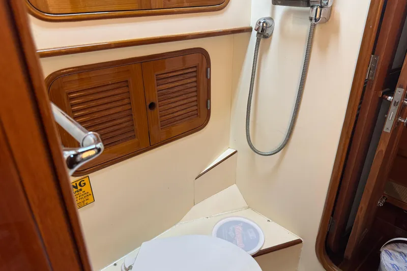 Slide: The Image of 1989 Mason 54 yacht bathroom with wooden cabinets and shower. - 36