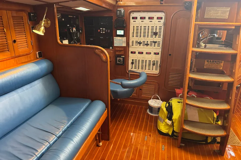 Slide: The Image of Interior of a 1989 Mason 54 yacht with blue seating and wooden finishes. - 13