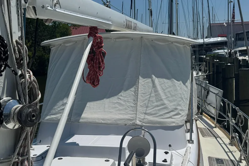 Slide: The Image of Sailboat deck with white canopy, Mason 54 model, 1989, docked at marina. - 50