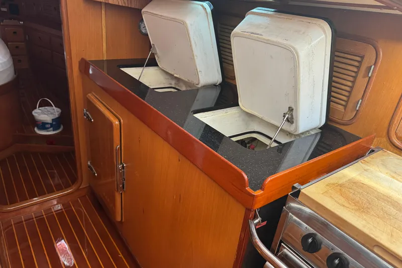 Slide: The Image of Wooden yacht kitchen with dual sinks, black countertop, and stove, Mason 54, 1989 model. - 19