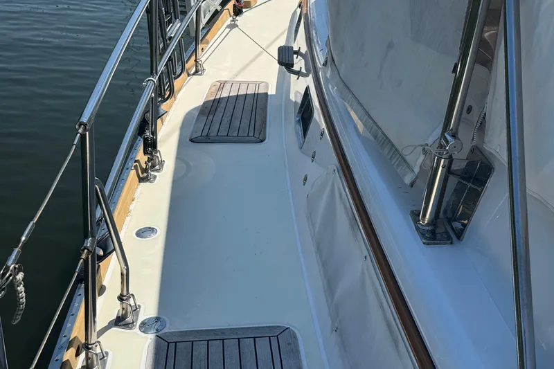 Slide: The Image of Deck view of a 1989 Mason 54 yacht, featuring polished railings and wooden accents. - 47