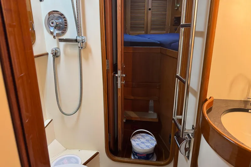Slide: The Image of Interior of a 1989 Mason 54 yacht featuring a compact bathroom and cozy cabin. - 7