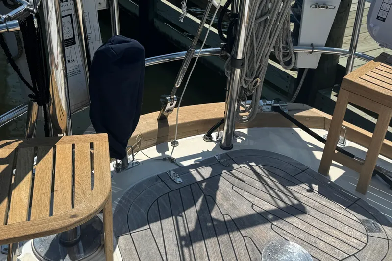 Slide: The Image of Wooden deck of a 1989 Mason 54 sailboat with seating and nautical equipment. - 56
